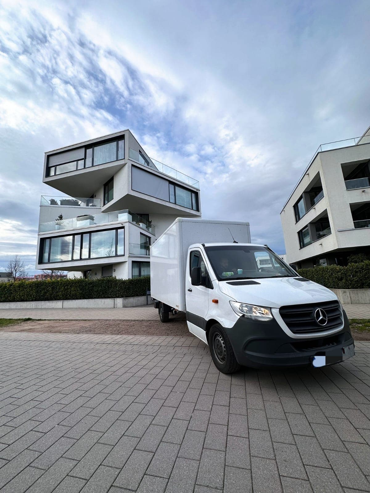 M+M Umzüge Transporter vor modernem Neubau