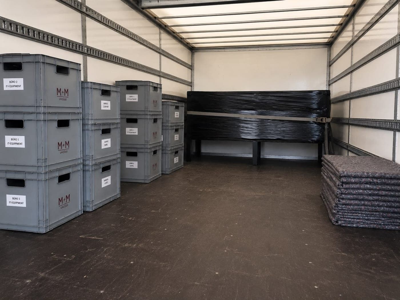 Nach Büro beschriftete IT-Kisten gesichert im Umzugs-LKW